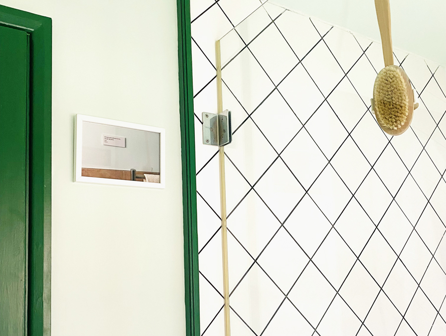 Image of a framed photograph on a bathroom wall. The photograph features a different bathroom wall.