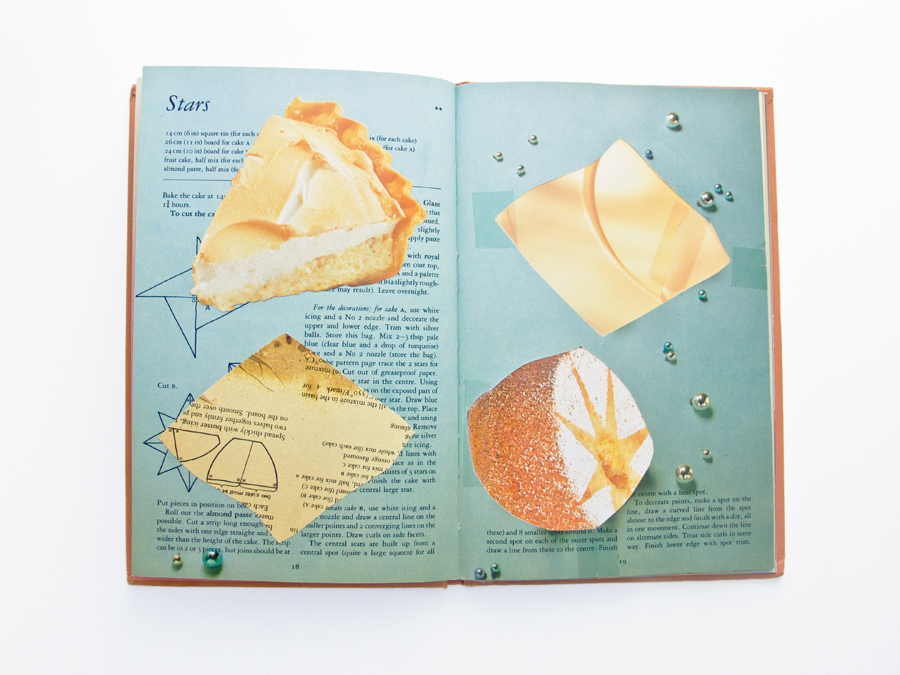 A mostly blue double page spread of a recipe book with four shapes affixed in a naive collage. These shapes are a slice of lemon meringue pie, two yellow beige diamonds and an icing sugared sponge cake.