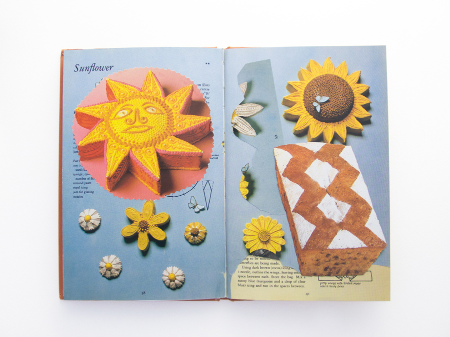 A mostly blue double page spread of a recipe book with snippets of other pages of recipe books afixed in a naive collage. The snippets feature a yellow iced sun, some sort of pound cake and a section of the original blue page cut out and afixed elsewhere.